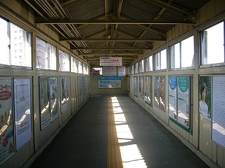 穏やかに日光の降り注ぐクリーム色に塗られた木造跨線橋内。