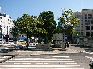 短い横断歩道を渡った先には、大きな木々三本と銅像、時計塔。