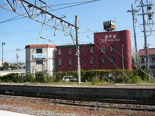 暗い赤色の三階建ての建物。