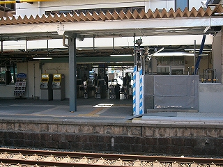 単式ホームにある改札口。右手には工事用の灰色のネット。