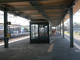 新設された平らな屋根の上屋の下にて。しかしそれは上屋ではなく、新駅舎の床の裏にあたる。少し暗くなったホームの中央には真新しい待合室が設けられた。