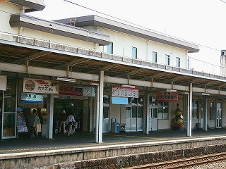 上屋から広告がいくつかぶら下がった単式ホーム。改札口の右側には大きな金のひょうたんのモニュメントが置かれていた。