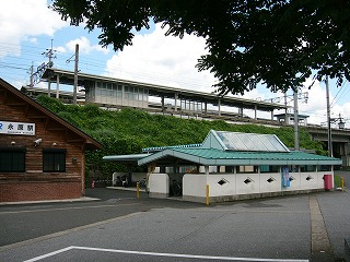 薄いクリームグリーンの屋根に三角の透明サンルーフのある駐輪所