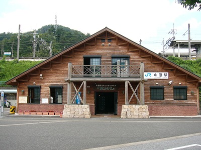 大きな三角の屋根の丸太作り2階ありのログハウス風の建物