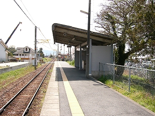 単線とホームと屋根を線路側に向かって長く延ばした小さな開放式待合所。