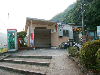 屋根が突き出した四角い入口。ただし右のほうは屋根の下に建物が続いていて屋根の下のスペースはない。