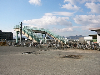 跨線橋を斜めに見て。下り線ホーム沿いに自転車がずらりと並べられている。