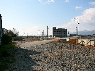 手前には広がるバラスト、奥のほうには貨車にバラストをトラックが運び込むための白いコンクリートのスロープが見える。