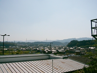 広がる民家。遠くに低い山並みが連なる。