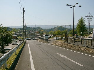 集落に向かって下る一本の坂道。右手に駐車場。ロータリーのため一方通行。