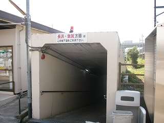 クリーム色の四角いコンクリートの地下道入口。コンクリートの地下通路の入口の上には赤色灯が設置されている。