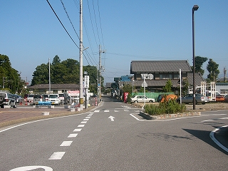 ロータリーのそばの太い道路から、先の方に続く細い街道を見て。