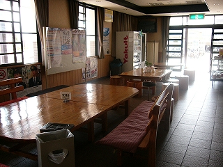 テーブルの並びを左斜めに見て。右向こうの入口からは光が差し込んでいる。