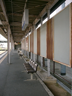 赤錆びた広告枠の並びとホーム。