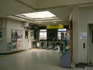 天井の明り取り窓から光が差し込む誰もいない改札口。
