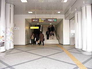 階段とエスカレーターの下り口。天井も床も白色。