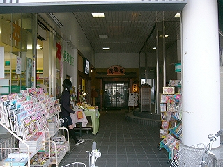 細長いスペース。左手に本の並ぶ本屋の裏口。突き当たりに居酒屋。