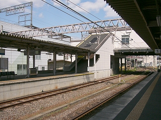 線路内の向こうにある階段下り口。全体的に白色で新しい感じ。