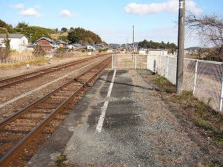 白い柵で行き止まりになったホーム終端付近。線路と反対側は舗装されず、砂利が広がっている。