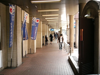 赤いレンガの敷き詰められた床と白い壁を持つ回廊。