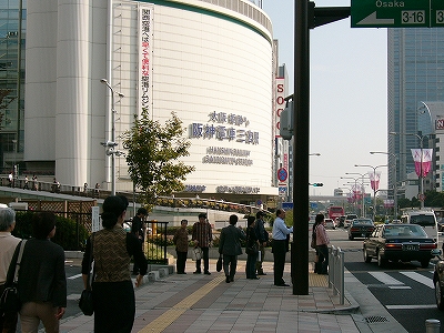 交差点の角にあって建物の角をカーブさせた背の高い大きな建物。