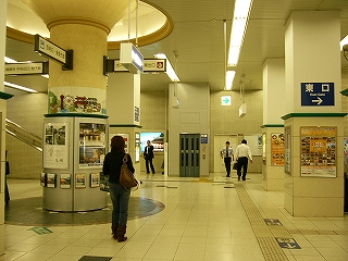 四角い柱と一本の丸い柱のある改札ないコンコース。全体的にクリーム色。