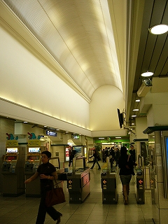 自動改札の並びとそこだけ背の高いドーム式の細長い天井。
