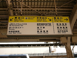 黄色と白と黒を使った電照式出口案内板。