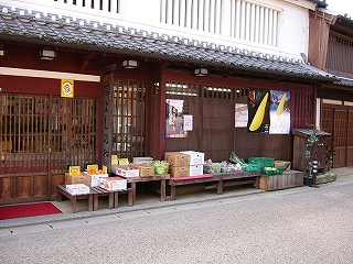 軒下の縁台に箱に入れた野菜を陳列しているお店。