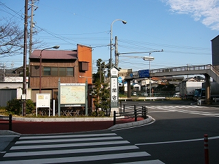 正面に駅前の駐車場への入口の道路を渡るための短い横断歩道があり、渡った先に観光案内板や「東海道　関宿」と掛かれたプラスティックの背の高い灯篭などがある。右手に国道1号へ出るＴ字路がある。