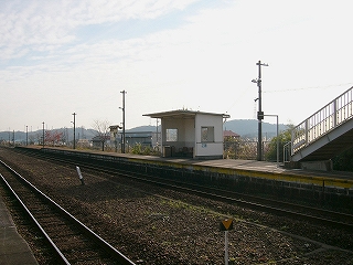 細長いホームにぽつんと立つ簡単な待合所。プレハブの建物の一つの面を取り除いたような待合所だが、庇はある程度伸びている。