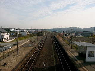 すじ雲のたなびく空の下にのびゆく二本のレール。中線があったため、遠い構内の先まで線路どうしは離れている。