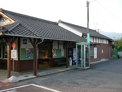 斜めから見た駅舎。大きな瓦屋根の端を、回廊をつくるように柱が支えている。