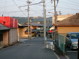 下り坂の先の、信号のついた小さな十字路。周りは住宅。