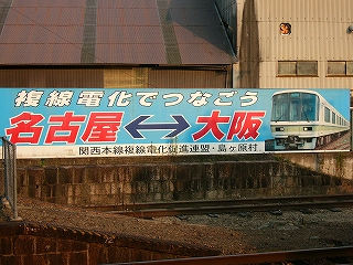 水色地に太い白い字と赤い字で書かれた横に長い大きな看板