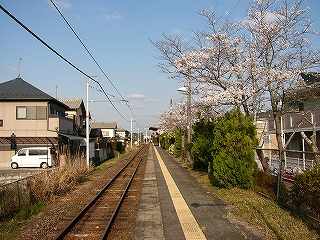 家の並び、線路内、ホーム、緑の植え込み。