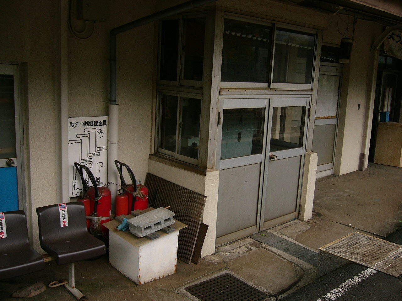 大きな消火器、茶色の椅子、機械室