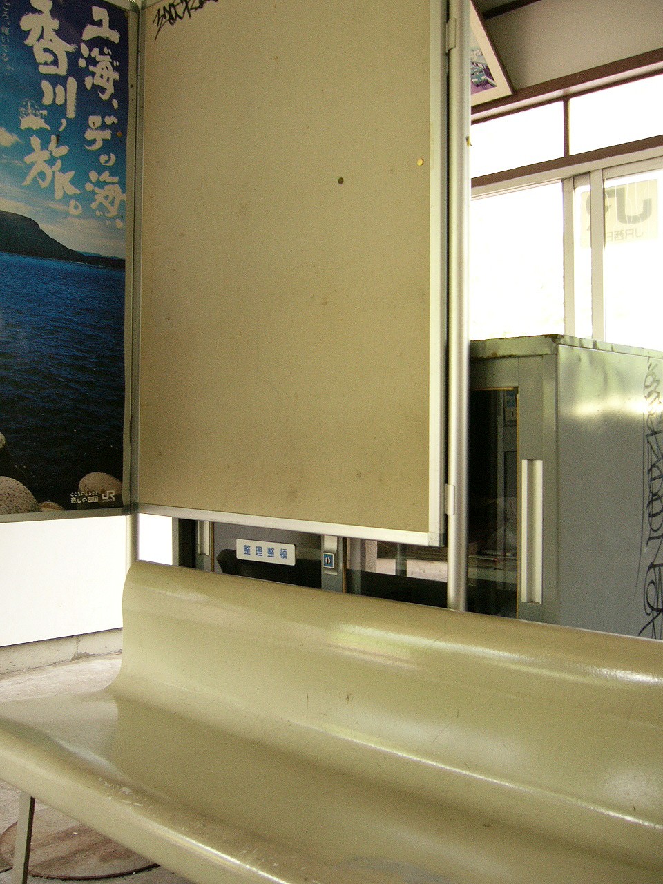 白いプラスティックの長椅子の後ろに鼠色の事務ロッカー