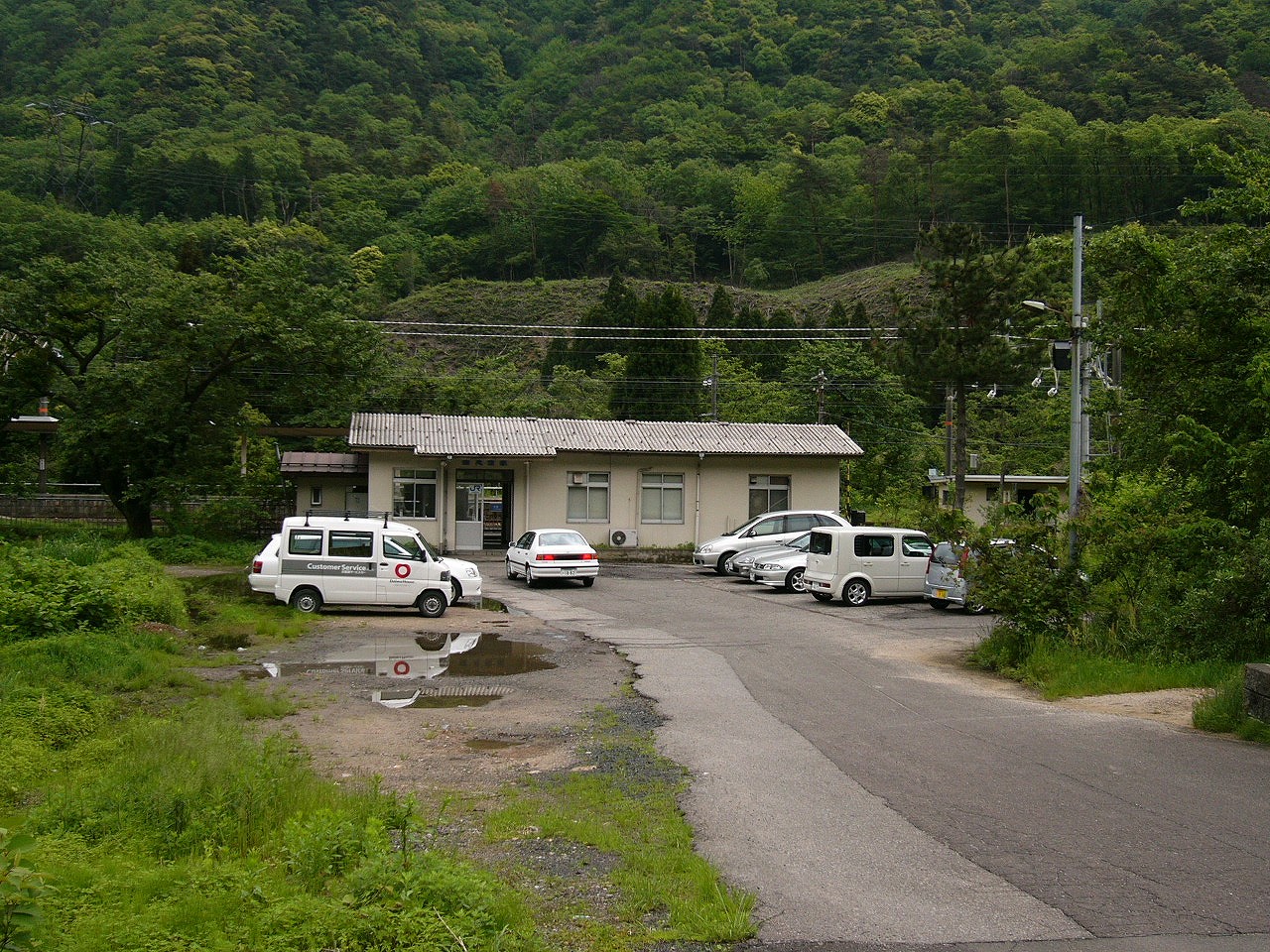 コンパクトで四角い駅舎を正面遠くから見て。