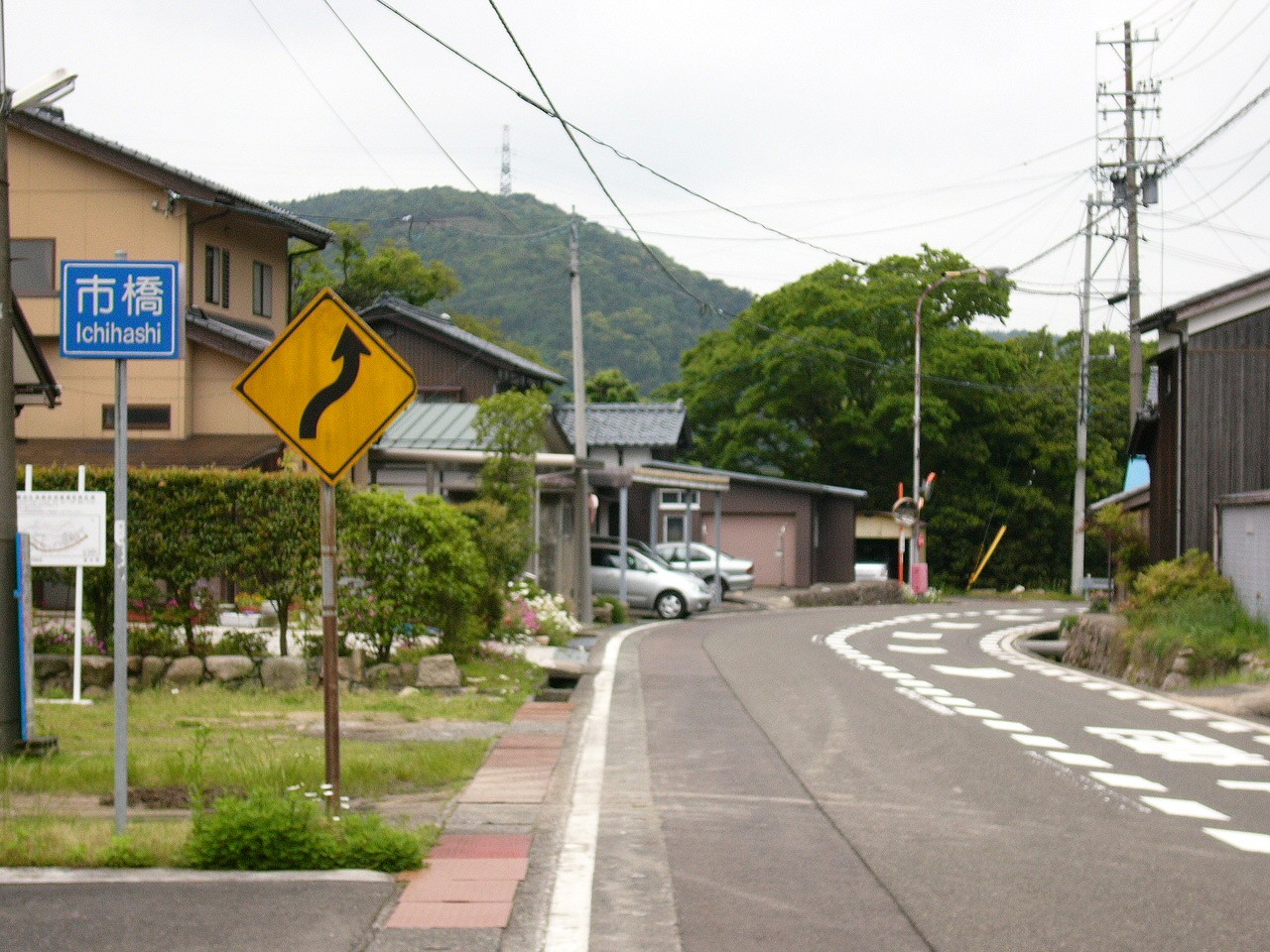 道の奥はカーブ。ミラーと大きな木