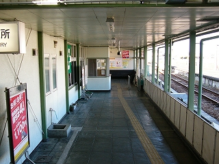 濃い鼠色の敷石の敷き詰められた改札口への通路。右手は1番線と低い板の柵で仕切られているだけだ。