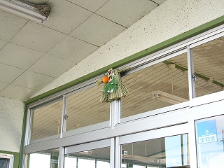 藁を束ねたしめ縄。みかんとしだの葉が付いている。