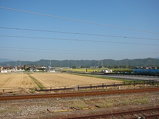 刈り入れの終わった田んぼの向こうに痩せた山地。