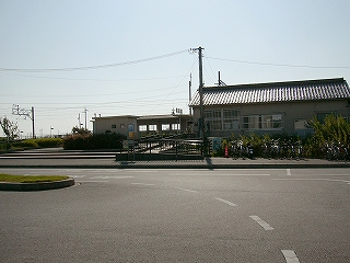 手前にロータリー、突き当たりに駅舎の側面。