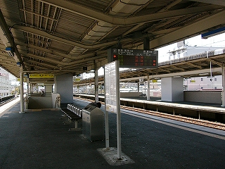 椅子、ゴミ箱、時刻表のある風景。