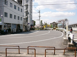 マンション、カーブしてこっちに来る二車線の道路。