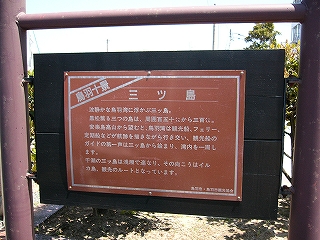 黒い木の板に赤茶色の鉄板を張った案内板。