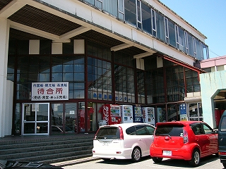 入口側はガラス張りで、暗い赤色の鉄枠の格子が入っている。