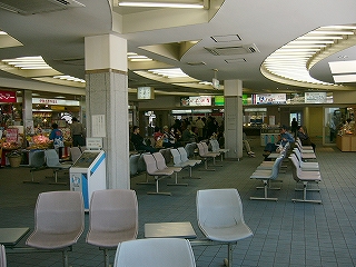 一人掛けの椅子がさまざまな形で配置される広い待合所。大きな窓からの明かりで明るい。