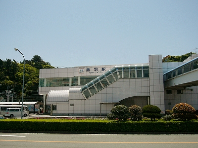 白い駅舎。右斜めにエスカレーターの明り取り窓。